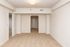 Bright, spacious room with neutral tones, plush carpeting, and elegant archway, perfect for versatile living space.