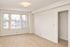Bright and airy room with large windows, plush carpet, and soft lighting, perfect for a cozy living space.