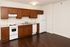 Modern kitchen with polished wooden cabinets, sleek countertops, and stainless steel appliances, featuring a spacious open floor layout.