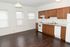 Bright kitchen with rich wooden cabinets, modern appliances, and elegant dark hardwood flooring.