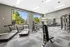 Bright and modern fitness center featuring treadmills, exercise bike, weight machines, and large windows with a scenic outdoor view.
