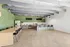 Modern communal kitchen area with sleek design, featuring a long dining table, bar seating, and elegant lighting accents.