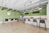 Modern apartment kitchen with sleek gray countertops, stylish bar seating, and contemporary green walls creating an inviting atmosphere.