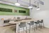 Modern kitchen area with sleek island seating, stylish pendant lights, and vibrant green accent wall, perfect for entertaining.