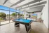 Luxurious recreation room with a sleek pool table, floor-to-ceiling windows, and scenic views, perfect for relaxation and entertainment.