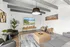 Modern living room with stylish decor, featuring cozy seating, a large flat-screen TV, and elegant artwork for a welcoming atmosphere.