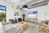 Chic modern living room with stylish furniture, large TV, and floor-to-ceiling windows showcasing a scenic view.