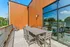 Chic rooftop terrace with modern outdoor dining set, wooden paneling, and expansive city views for perfect summer gatherings.