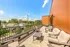 Chic rooftop terrace with comfortable seating, offering stunning views of a picturesque neighborhood under a clear blue sky.