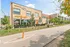 Contemporary Monon 46 building featuring vibrant outdoor seating and lush greenery along a scenic pathway.