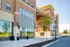 Modern brick apartment complex with expansive windows, scenic surroundings, and welcoming entrance.