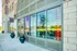 Inviting leasing office exterior with elegant glass paneling and vibrant potted plants, showcasing modern architecture.