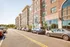 Charming brick apartment complex with large arched windows and vibrant street view, offering modern urban living.