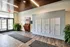 Modern apartment lobby with elegant tile flooring, secure mailboxes, and lush green plants, creating a welcoming entryway.
