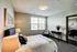 Bright and inviting bedroom featuring a plush bed, elegant decor, and abundant natural light from large windows.