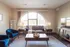 Inviting living room with elegant arch window, stylish blue chairs, and cozy gray sofa, perfect for relaxation.