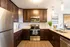 Sleek modern kitchen boasting stainless steel appliances, rich wood cabinetry, and elegant pendant lighting.