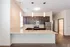 Modern kitchen with granite countertops, stainless steel appliances, and pendant lighting in a sleek apartment setting.