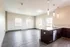 Bright, open-concept apartment featuring sleek hardwood floors, modern kitchen with dark cabinets, and ample natural light from large windows.