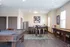 Elegant recreation room featuring a stylish pool table, modern bar seating, and sleek stainless steel appliances.