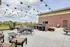 Charming outdoor patio with elegant seating, barbecue grill, and stunning countryside views, adorned with festive string lights.