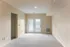 Inviting apartment interior showcasing a spacious, light-filled room with soft carpet and elegant double doors leading to an outdoor view.