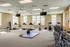 Spacious and well-lit apartment gym with modern equipment, including treadmills, stationary bikes, and free weights, creating an inviting fitness atmosphere.