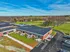 Charming brick apartment complex surrounded by lush green lawns and picturesque countryside views, perfect for tranquil living.
