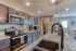 Modern kitchen featuring sleek granite countertops, stainless steel appliances, and stylish dark wood cabinets, complete with a spacious pantry.