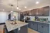 Modern kitchen adorned with elegant dark cabinetry, sleek granite countertops, and stylish pendant lighting, creating a warm and inviting atmosphere.