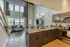 Modern open-concept living area with high ceilings, stylish kitchen, and cozy seating, offering abundant natural light and scenic views.
