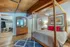 Inviting bedroom with wooden ceiling, stylish four-poster bed, vibrant artwork, and ample closet space.