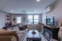 Cozy living room with stylish decor, featuring a plush sofa, rustic wooden table, and large window with a scenic view.
