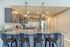 Modern kitchen with granite countertops, stylish pendant lights, and sleek stainless steel appliances, perfect for culinary enthusiasts.
