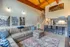 Bright modern loft with high ceilings, featuring an inviting open-plan living area, stylish kitchen with bar seating, and cozy sectional sofa, accentuated by artistic wall photography and a vibrant rug.