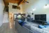 Modern open-concept living room with high ceilings, stylish kitchen, and loft space, featuring a sleek TV setup and cozy seating area.