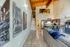 Chic loft apartment showcasing modern decor, open-concept living area, stylish kitchen, and artistic wall designs with natural light enhancing wooden ceiling beams.