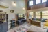 Bright and inviting living room with modern decor, featuring a plush sofa, stylish rug, large windows, and a sleek entertainment setup.