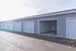 Modern garage units with sleek gray siding and white doors, showcasing ample storage space in a neat, well-maintained area.