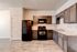 Modern kitchen with sleek dark cabinets, marble countertops, and contemporary appliances, perfect for culinary enthusiasts.