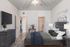 Elegant bedroom with modern grey furniture, cozy lighting, and a spacious walk-in closet, creating a serene and inviting atmosphere.