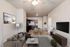 Inviting living room with stylish decor, cozy sofa, and modern kitchen in the background, highlighting an open-concept space.