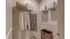 Elegant walk-in closet with organized shelving, stylish clothing, and efficient storage bins.