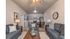 Inviting modern living room with cozy gray sofas, a stylish wooden coffee table, and elegant decor leading into a charming open kitchen with sleek cabinetry and dining area.