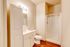 Bright modern bathroom featuring sleek white cabinetry, a pristine shower area, and warm wooden flooring for a cozy ambiance.