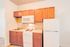 Cozy kitchen with elegant wooden cabinets, compact appliances, and a bright, inviting atmosphere.