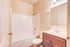 Modern bathroom featuring a sleek bathtub, elegant wooden vanity, and bright ambient lighting.
