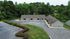 Charming apartment complex nestled in lush greenery with ample parking and serene surroundings.