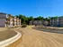 Charming new apartment complex under construction with modern architecture, promising a vibrant community atmosphere surrounded by lush greenery.