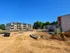 Exciting new apartment complex under construction, showcasing modern architecture and expansive green spaces in a serene setting.